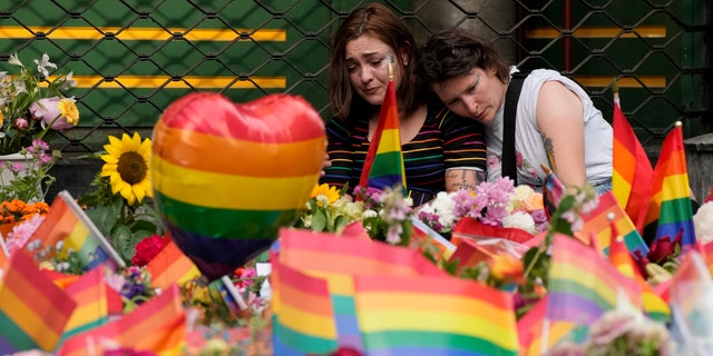People comfort each other at the scene of a shooting in central Oslo, Norway, Saturday, June 25, 2022. A gunman who opened fire in Oslo’s nightlife district has killed two people and left more than 20 others injured during the LGBTQ Pride festival in Norway's capital. (AP Photo/Sergei Grits)