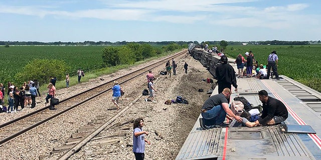 In this photo provided by Dax McDonald, an Amtrak passenger train lies on its side after derailing near Mendon, Mo., on Monday, June 27, 2022. 