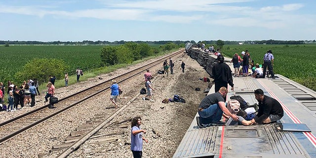 In this photo provided by Dax McDonald, an Amtrak passenger train lies on its side after derailing near Mendon, Mo., on Monday, June 27, 2022.