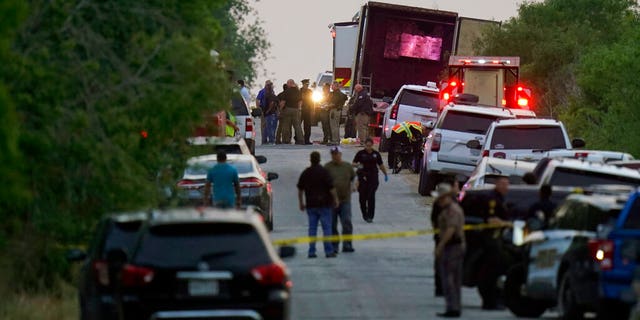 Police and other first responders work the scene where officials say dozens of people have been found dead and multiple others were taken to hospitals with heat-related illnesses after a semitrailer containing suspected migrants was found.
