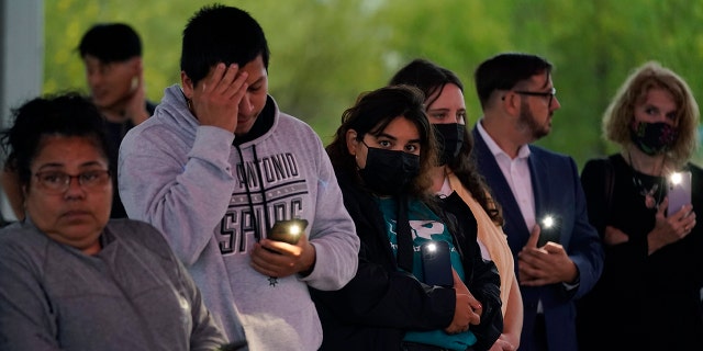 Members of the community take part in a vigil for the dozens of people have been found dead Monday in a semitrailer containing suspected migrants, Tuesday, June 28, 2022, in San Antonio.