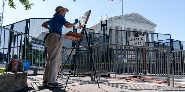 Artist Elaine Wilson works on a painting of the Supreme Court.