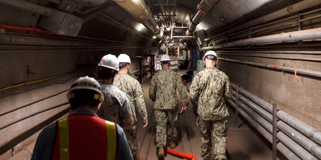 FILE - In this Dec. 23, 2021, photo provided by the U.S. Navy, Rear Adm. John Korka, Commander, Naval Facilities Engineering Systems Command (NAVFAC), and Chief of Civil Engineers, leads Navy and civilian water quality recovery experts through the tunnels of the Red Hill Bulk Fuel Storage Facility, near Pearl Harbor, Hawaii. A Navy investigation released Thursday, June 30, 2022 revealed that shoddy management and human error caused fuel to leak into Pearl Harbor's tap water last year, poisoning thousands of people and forcing military families to evacuate their homes for hotels. The investigation is the first detailed account of how jet fuel from the Red Hill Bulk Fuel Storage Facility, a massive World War II-era military-fun tank farm in the hills above Pearl Harbor, leaked into a well that supplied water to housing and offices in and around Pearl Harbor.