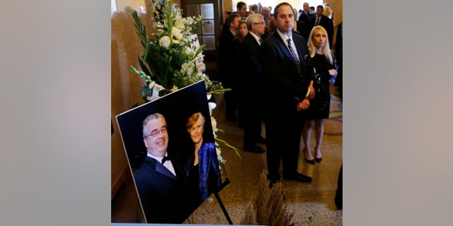 People file past a portrait of John and Joyce Sheridan to a memorial service for the couple at the War Memorial Oct. 7, 2014, in Trenton, N.J.