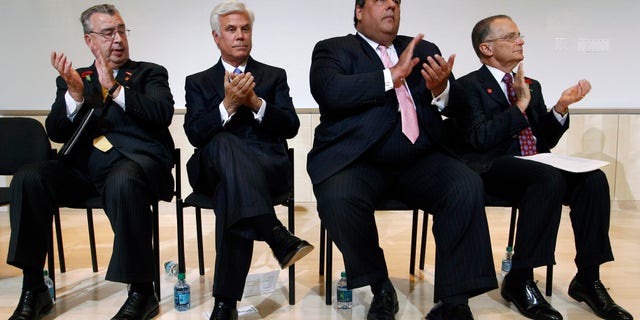 In this July, 24, 2012, file photo, John Sheridan, president and CEO of the Cooper Health System, left, applauds with George Norcross III, New Jersey Gov. Chris Christie and Dr. Paul Katz during an event in Camden, N.J. 