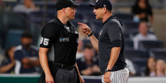 New York Yankees manager Aaron Boone (17) has words with home plate umpire Stu Scheurwater (85) after being thrown out of the game in the eighth inning against the Oakland Athletics, Tuesday, June 28, 2022, in New York.