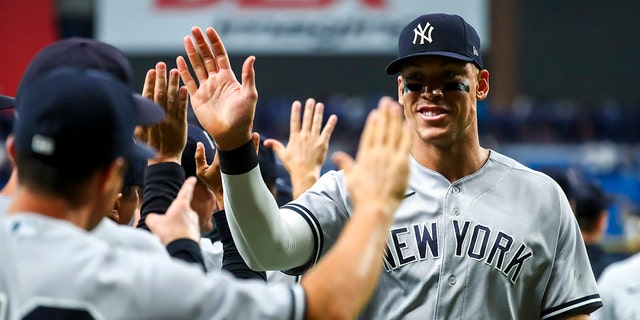 Aaron Judge of the New York Yankees high-fives teammates after beating the Tampa Bay Rays 4-2 at Tropicana Field on June 20, 2022, in St Petersburg.