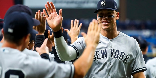 Aaron Judge of the New York Yankees high-fives teammates after beating the Tampa Bay Rays 4-2 at Tropicana Field on June 20, 2022, in St Petersburg.