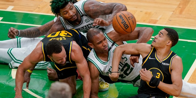 Boston Celtics center Al Horford (42) and guard Marcus Smart, top, battle for a loose ball against Golden State Warriors guard Jordan Poole (3) and guard Stephen Curry (30) during the fourth quarter of Game 3 of basketball's NBA Finals, Wednesday, June 8, 2022, in Boston.