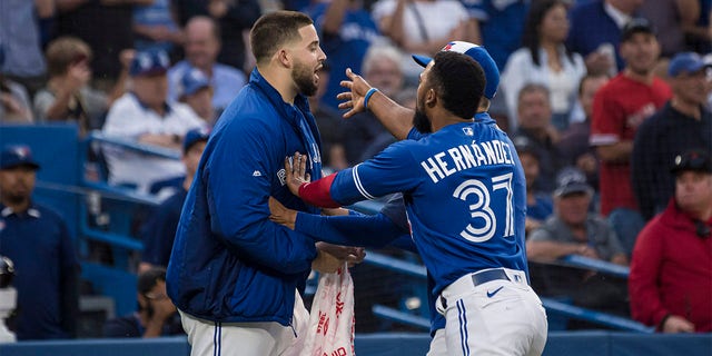 Toronto Blue Jays pitcher Alec Manoa, left, is held back by outfielder Teoscar Hernandez during a heated exchange with the Boston Red Sox after Alejandro Kirk of the Blue Jays hit the pitch during the fourth inning of a baseball game Wednesday, June 29, 2022 Gone.  , in Toronto. 