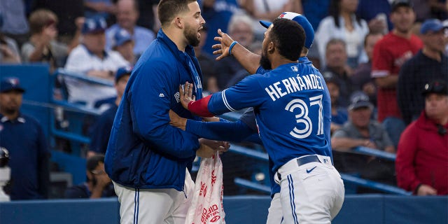 Toronto Blue Jays pitcher Alek Manoah, left, is held back by outfielder Teoscar Hernandez during a heated exchange with the Boston Red Sox after Blue Jays' Alejandro Kirk was hit by a pitch during the fourth inning of a baseball game Wednesday, June 29, 2022, in Toronto.