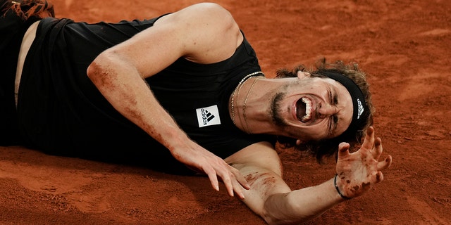Germany's Alexander Zverev grimaces in pain after twisting his ankle during the semifinal match against Spain's Rafael Nadal at the French Open tennis tournament in Roland Garros stadium in Paris, France, Friday, June 3, 2022.