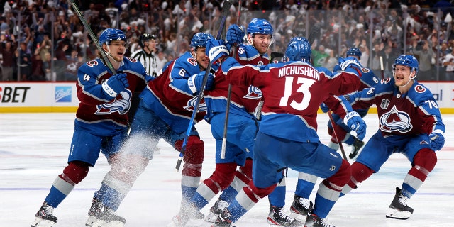 Andre Burakovsky, #95 of the Colorado Avalanche, celebrates with teammates after scoring a goal against Andrei Vasilevskiy, #88 of the Tampa Bay Lightning, during overtime to win Game One of the 2022 Stanley Cup Final 4-3 at Ball Arena on June 15, 2022 in Denver, Colorado.