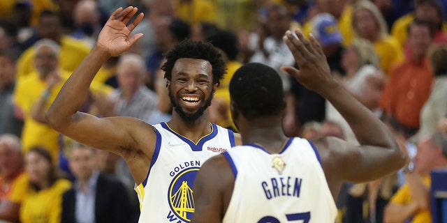 Golden State Warriors forward Andrew Wiggins, left, celebrates with forward Draymond Green (23) during the first half of Game 5 of basketball's NBA Finals against the Boston Celtics in San Francisco, Monday, June 13, 2022. 