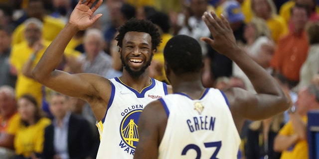 El alero de los Golden State Warriors, Andrew Wiggins, a la izquierda, celebra con el alero Draymond Green (23) durante la primera mitad del Juego 5 de las Finales de la NBA contra los Boston Celtics en San Francisco el 13 de junio de 2022. 