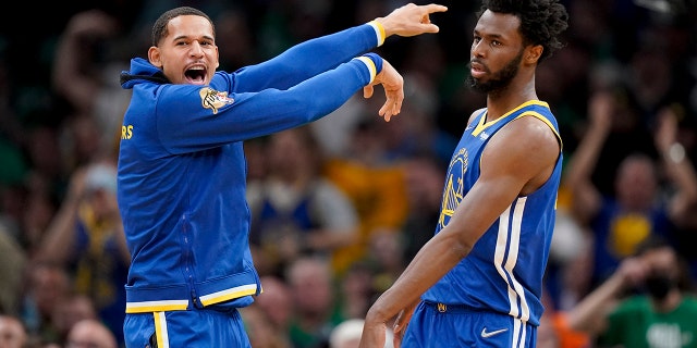 Golden State Warriors forward Andrew Wiggins, #22, reacts with forward Juan Toscano-Anderson, #95, during the second quarter Game 6 of basketball's NBA Finals against the Boston Celtics, Thursday, June 16, 2022, in Boston.