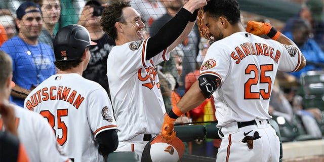 Austin Hayes of the Baltimore Orioles holds the home run chain on Anthony Santander, who scored a home run against the Washington Nationals during the third inning of a baseball game on Wednesday, June 22, 2022 in Baltimore.