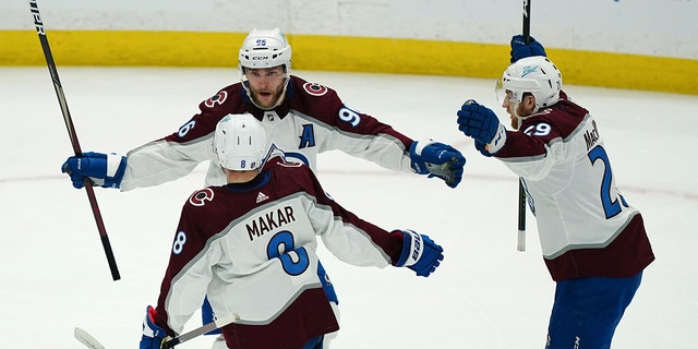 Colorado Avalanche right wing Mikko Rantanen (96), center Nathan MacKinnon (29) and defenseman Cale Makar (8) celebrate after a goal during the second period of Game 4 of the NHL hockey Stanley Cup Finals against the Tampa Bay Lightning on Wednesday, June 22, 2022, in Tampa, Fla.