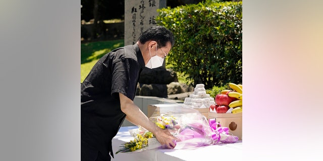 Japan's Prime Minister Fumio Kishida offers a bouquet of flowers in front of a memorial at the Peace Memorial Park in Itoman, Okinawa, southern Japan Thursday, June 23, 2022. Japan marked the Battle of Okinawa, one of the bloodiest battles of World War II fought on the southern Japanese island, which ended 77 years ago, Thursday. (Kyodo News via AP)