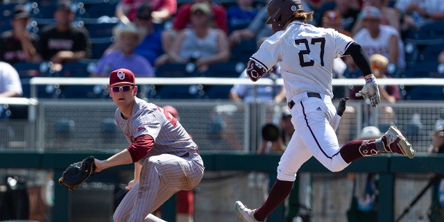Oklahoma infielder Blake Robertson puts out Texas A&M Dylan Rock (27) at first during the seventh inning of an NCAA College World Series baseball game Friday, June 17, 2022, in Omaha, Neb.