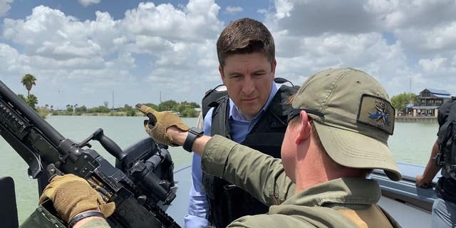 House Select Committee on Economic Disparity and Fairness in Growth Ranking Member Bryan Steil, R-Wis., speaks with a Texas Department of Public Safety trooper on a boat patrolling the Rio Grande on June 17, 2022. 