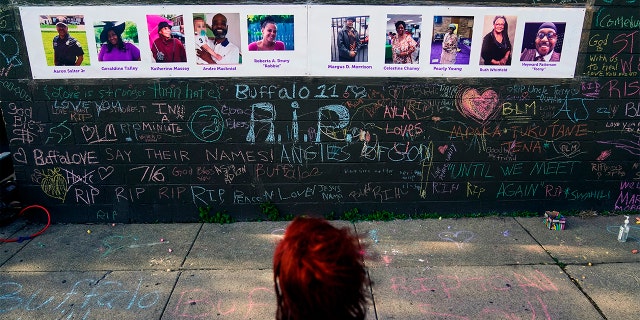 A person visits a makeshift memorial near the scene of Saturday's shooting at a supermarket, in Buffalo, on May 19, 2022, six days before the second anniversary of George Floyd's killing.