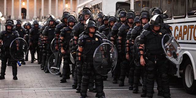 Capitol police stand dressed in riot gear as protestors gather near the Supreme Court in response to the ruling on Roe v. Wade.