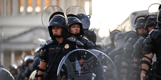 Capitol Police stand dressed in riot gear as protesters gather near the Supreme Court in response to the Roe v.  Wade.