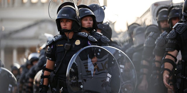 Capitol police stand dressed in riot gear as protestors gather near the Supreme Court in response to the ruling on Roe v. Wade.