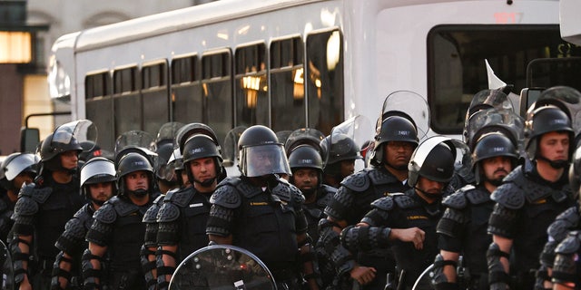 Capitol police stand dressed in riot gear as protestors gather near the Supreme Court in response to the ruling on Roe v. Wade.