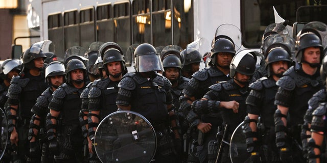 Capitol police stand dressed in riot gear as protestors gather near the Supreme Court in response to the ruling on Roe v. Wade.