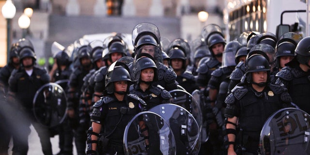 Capitol police stand dressed in riot gear as protestors gather near the Supreme Court in response to the ruling on Roe v. Wade.