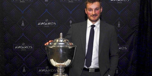 Colorado Avalanche's Cale Makar poses with the Norris Trophy after the NHL hockey awards Tuesday, June 21, 2022, in Tampa, Fla. The Norris Trophy is presented annually to the leagues' best defenseman. 