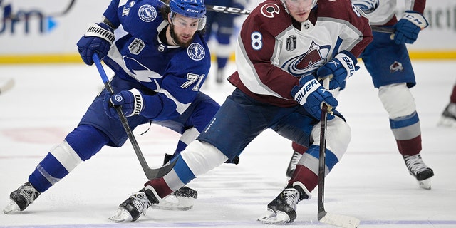 Colorado Avalanche defenseman Cale Makar (8) controls the puck next to Tampa Bay Lightning center Anthony Cirelli (71) during the third period of Game 4 of the NHL hockey Stanley Cup Finals on Wednesday, junio 22, 2022, in Tampa, Fla. 