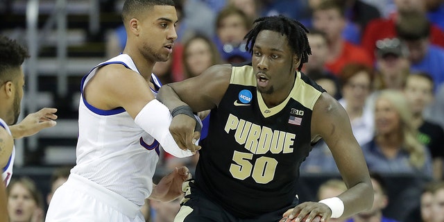 Caleb Swanigan of the Purdue Boilermakers is defended by Landen Lucas of the Jayhawks during the NCAA Men's Basketball Tournament Midwest Regional on March 23, 2017 in Kansas City, Missouri.