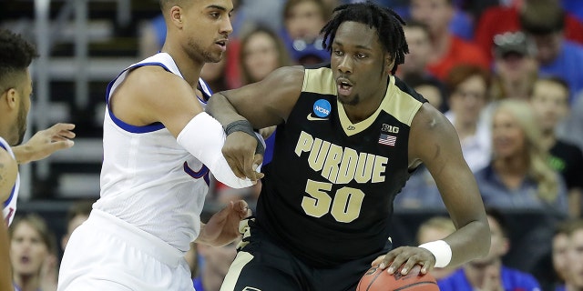 Caleb Swanigan of the Purdue Boilermakers is defended by Landen Lucas of the Jayhawks during the NCAA Men's Basketball Tournament Midwest Regional on March 23, 2017 in Kansas City, Missouri.