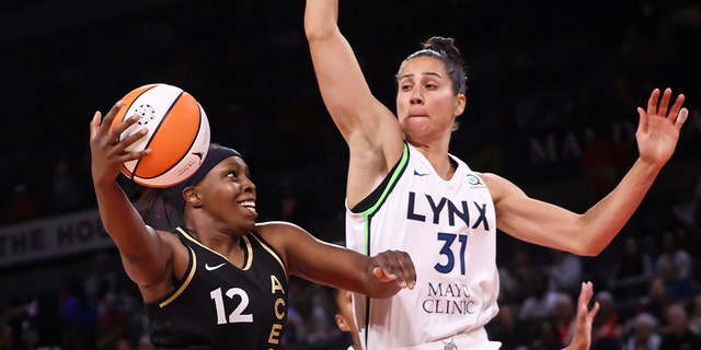 Las Vegas Aces guard Chelsea Gray (12) drives into the basket against Minnesota Lynx center Nicolina Milik (31) during the first half of a WNBA basketball game on Sunday, June 19, 2022 in Las Vegas. 