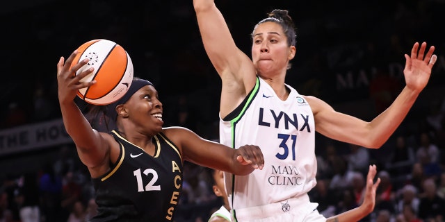 Las Vegas Aces guard Chelsea Gray (12) drives to the basket against Minnesota Lynx center Nikolina Milic (31) during the first half of a WNBA basketball game Sunday, June 19, 2022, in Las Vegas. 