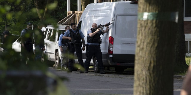 Chicago police surround a house in the 6300 block of South Bishop Street after a police officer was shot nearby on Wednesday, June 1, 2022.