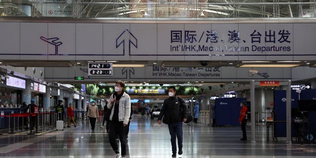 Reizigers lopen in een terminalhal op Beijing Capital International Airport in Beijing, China, op 23 maart 2022.