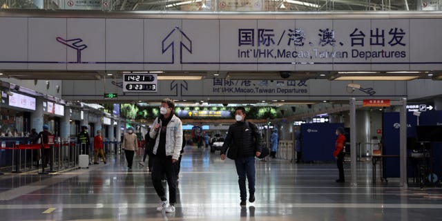 Reizigers lopen in een terminalhal op Beijing Capital International Airport in Beijing, China, op 23 maart 2022.