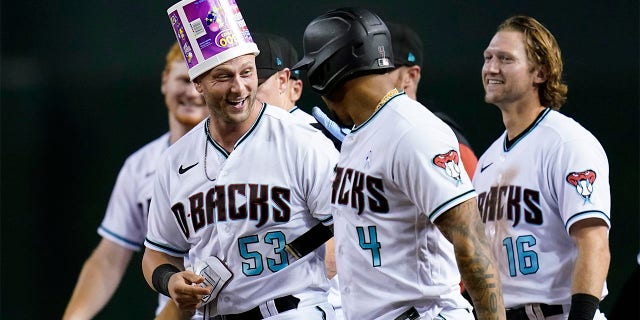 Arizona Diamondbacks' Christian Walker (53) celebrates with Ketel Marte (4) and Jake Hager (16) after Walker grounder on which Josh Rojas scored the winning run against the San Diego Padres during the ninth inning of a baseball game Tuesday, June 28, 2022, in Phoenix. The Diamondbacks won 7-6.