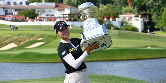 In Gee Chun, of South Korea, poses with the winners trophy after winning the KPMG Women's PGA Championship golf tournament at Congressional Country Club, Sunday, June 26, 2022, in Bethesda, Md.