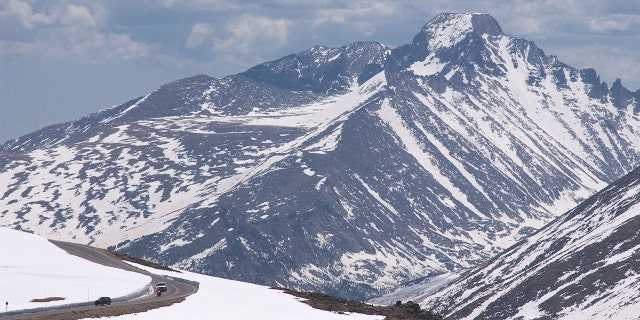 Cars drive down the Trail Ridge Road in Rocky Mountain National Park, Colorado. Rising to an altitude of 12,183 feet above sea level, the road is the highest contiguous paved highway in the country.