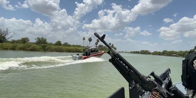 In an image taken from a Texas Department of Public Safety boat, a US Coast Guard vessel patrols the Rio Grande. 