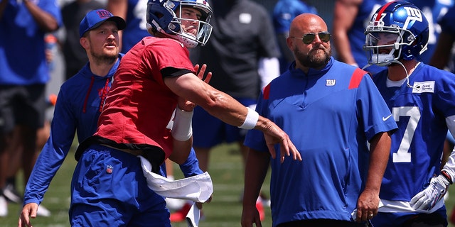 Quarterback Daniel Jones, #8 of the New York Giants, throws a pass as head coach Brian Daboll, right, looks on during mandatory minicamp at Quest Diagnostics Training Center on June 8, 2022 in East Rutherford, New Jersey.