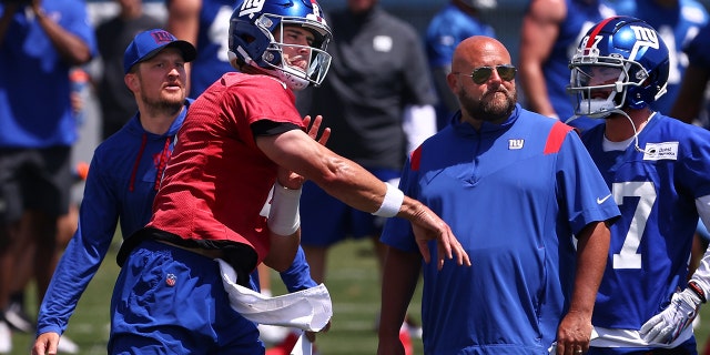 Quarterback Daniel Jones, #8 of the New York Giants, throws a pass as head coach Brian Daboll, right, looks on during mandatory minicamp at Quest Diagnostics Training Center on June 8, 2022 in East Rutherford, New Jersey.