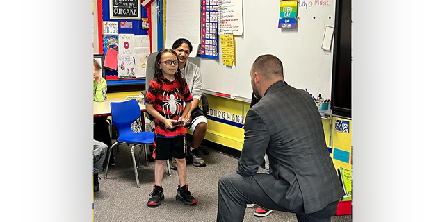 Proud father David Diaz Sr. (in back, left, behind his son) looks on as David Diaz Jr., 7, is presented with a New York State Senate Commendation Award in June 2022. "He's an angel in my eyes," said the proud dad about his son.