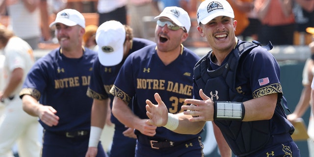 Notre Dame catcher David LaManna, right, celebrates with teammates after defeating Tennessee in an NCAA college baseball super regional game Sunday, June 12, 2022, in Knoxville, Tenn.