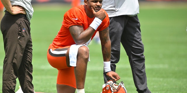 Cleveland Browns quarterback Deshaun Watson kneels on the field during practice at the team's training facility on Wednesday, June 8, 2022 in Berea, Ohio.